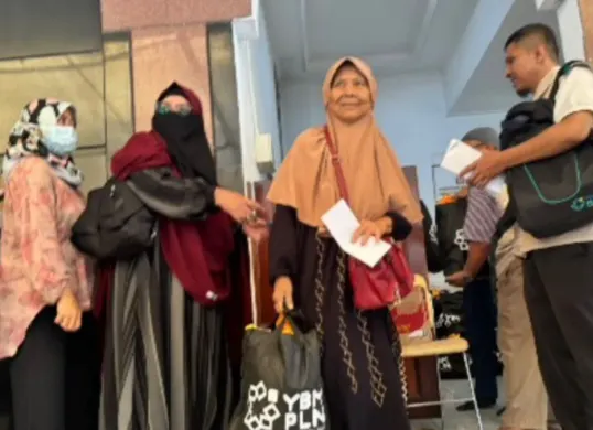 Seorang warga menerima paket sembako dalam program Berbagi Bingkisan Ramadhan, Cahaya Berkah Ramadhan 1447 H yang digelar YBM PLN UID Jakarta Raya di Masjid Nurul Falah, Gambir, Jakarta Pusat. (Sumber: Istimewa)