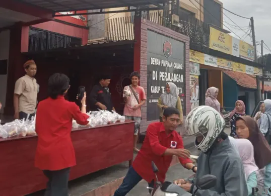 Pengurus DPC PDI Perjuangan Purwakarta membagikan takjil gratis kepada warga dan pengguna jalan, Jumat, 27 Februari 2026. (Sumber: Poskota/Dadan Sukmana)