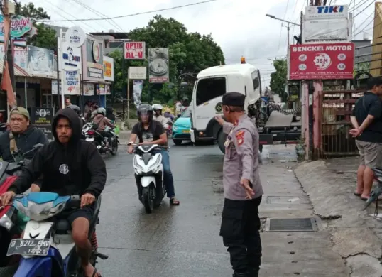 Petugas mengatur lalu lintas di lokasi truk kontainer peti kemas terperosok di Jalan Raya Limo, Kota Depok, Sabtu, 3 Januari 2026. (Sumber: Dok. Polsek Cinere)
