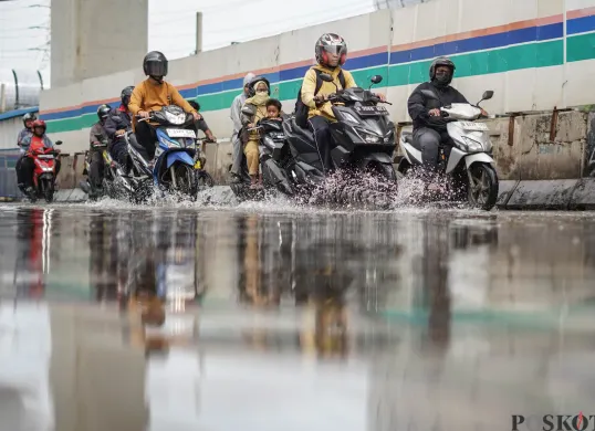 Pengendara melintasi banjir di Jalan R.E Martadinata, Tanjung Priok, Jakarta Utara. (Sumber: Poskota/Bilal Nugraha Ginanjar)