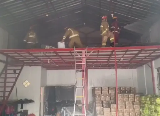 Petugas Damkar melakukan pendinginan usai api padam saat kebakaran melanda gudang kasur dan sembako di wilayah Cileungsi. (Sumber: Istimewa)