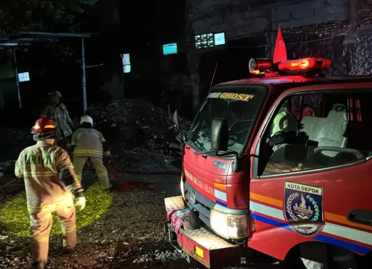 Petugas Damkar Kota Depok melakukan proses pemadaman di lokasi kebakaran rumah dan kontrakan Kecamatan Cimanggis, Depok, Selasa, 6 Januari 2026, malam. Kebakaran terjadi saat ponsel yang dicas di atas kasur. (Sumber: Istimewa)
