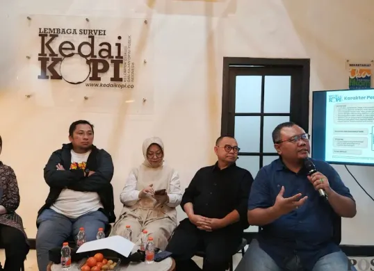 Founder Lembaga Survei KedaiKOPI, Hendri Satrio (kanan), saat membeberkan hasil risetnya di Tebet, Jakarta Selatan, Minggu, 11 Januari 2026. (Sumber: Poskota/Ali Mansur)