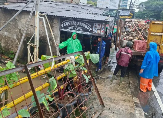 Wadanramil Sawangan Kapten Inf Sumarno turun langsung menangani luapan air Kali Angke hingga membanjiri masuk ke dalam kantor BJB dan Samsat Bojongsari Lama hingga pelayanan ditutup sementara waktu. (Sumber: Poskota/Angga Pahlevi)