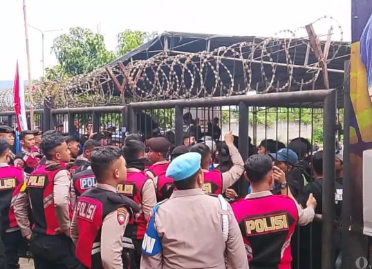 Aparat kepolisian menahan aksi bobotoh yang memaksa masuk ke dalam stadion, Minggu 11 Januari 2025. (Sumber: Poskota/Gatot Poedji Utomo)