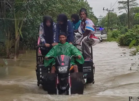 Pelaku jasa ojek tosa di Pagelaran, Pandeglang, saat mengangkut warga di tengah banjir merendam jalan raya. (Sumber: Poskota/Samsul Fatoni)