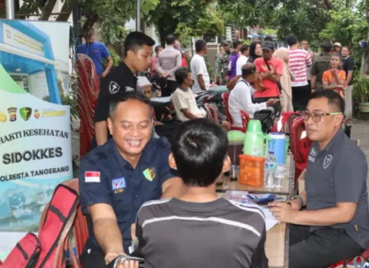 Tim medis Polresta Tangerang saat melakukan pemeriksaan kesehatan warga terdampak banjir. (Sumber: Poskota/Veronica)
