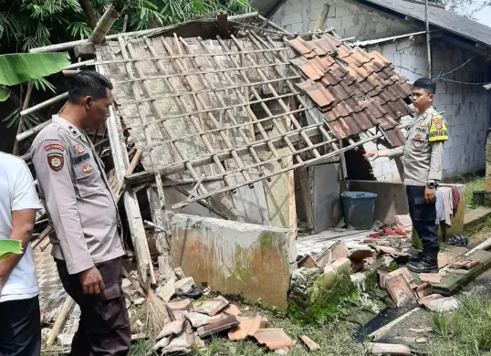 Petugas Polsek Pamarayan melakukan pengecekan terhadap kondisi rumah roboh milik Kulsum yang tidak layak huni. (Sumber: Istimewa)