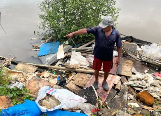 Warga menunjukan kawasan tanggul Muara Baru, Penjaringan, Jakarta Utara yang dipenuhi sampah, Sabtu, 17 Januari 2026. (Sumber: Poskota/Pandi Ramedhan)