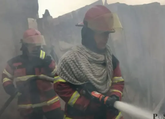 Petugas Damkar Bandung Barat melakukan pendinginan kios sandal di Kecamatan Cihampelas, Kabupaten Bandung Barat, Senin, 19 Januari 2026. (Sumber: Poskota/Gatot Poedji Utomo)