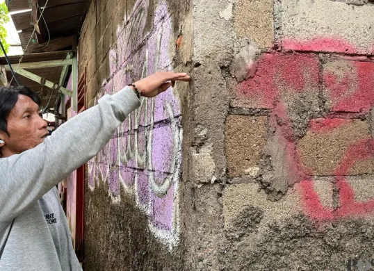 Yudi warga RW 05 Kelurahan Rawa Terate, Jakarta Timur sambil menunjuk bekas batas air di dinding rumahnya, Senin, 19 Januari 2026. (Sumber: Poskota/M Tegar Jihad)