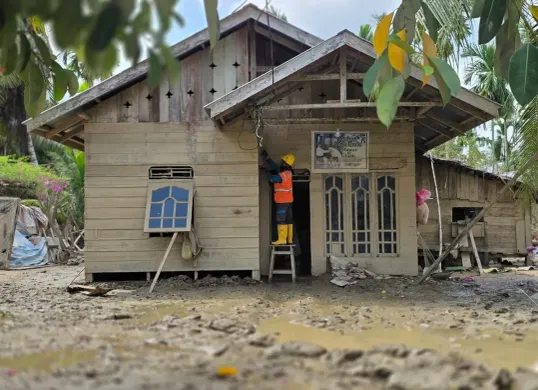 Di tengah sisa lumpur pascabencana hidrometeorologi, petugas PLN UID Jakarta Raya melakukan pemulihan listrik rumah warga di Aceh. (Sumber: Istimewa)