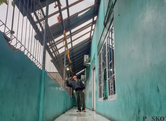 Petugas keamanan memeriksa bangunan yang hancur akibat angin puting beliung di Sekolah Dasar Islam (SDI) Baburidho, Kalibaru, Cilincing, Jakarta Utara, Selasa, 27 Januari 2026. (Sumber: Poskota/Bilal Nugraha Ginanjar)