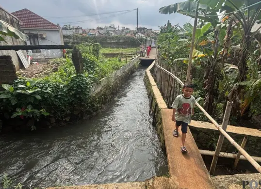 Lokasi hanyutnya seorang bocah di Kali Jantung, Kelurahan Pabuaran Mekar, Kecamatan Cibinong, Kabupaten Bogor, Kamis, 29 Januari 2026. (Sumber: Poskota/Giffar Rivana)