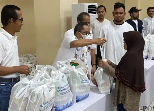 Wakil Wali Kota Jakarta Selatan, Ali Murtadho dan General Manager PLN UID Jakarta Raya, Moch Andy Adchaminoerdin, simbolis menyerahkan paket sembako murah dalam kegiatan 'Terang Berkah Ramadan'. (Sumber: Poskota/Guruh Nara Persada)