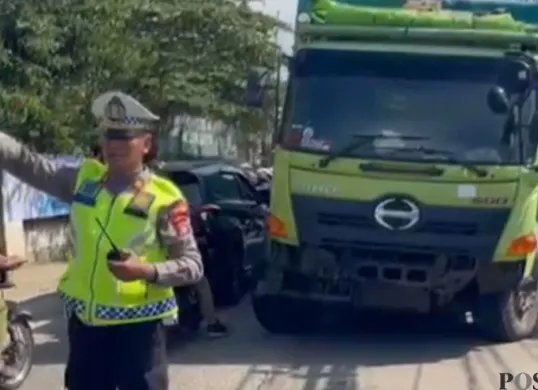 Proses evakuasi truk fuso yang masuk ke gorong-gorong. (Sumber: Poskota/Angga Pahlevi)