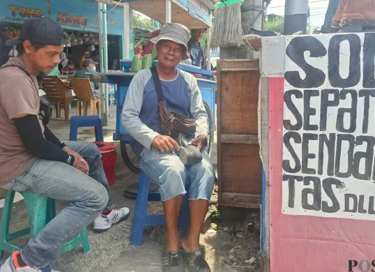 Yanto, 64 tahun, tukang reparasi sol sepatu, melayani pelanggan di lapaknya, Pasar Depok Lama, Jalan Dewi Sartika, Pancoran Mas, Kota Depok, Rabu, 11 Maret 2026. (Sumber: Poskota/Angga Pahlevi)