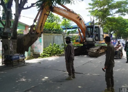 Anggota Satpol PP Kabupaten Tangerang membongkar bangunan liar di Jalan Raya Desa Keramat, Kecamatan Pakuhaji. (Sumber: Poskota/Veronica Prasetio)