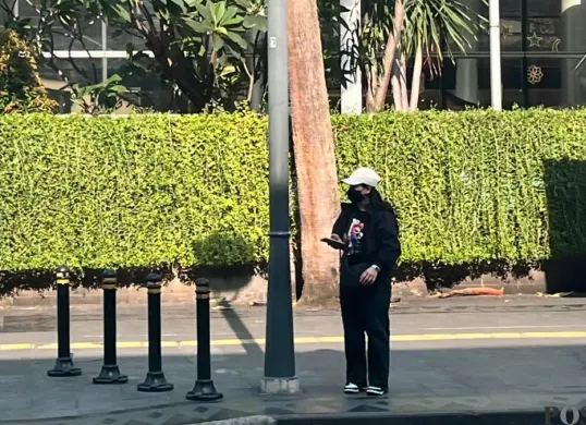 Seorang warga melindungi dirinya dari panas matahari dengan mengenakan jaket dan topi sinar matahari, Sabtu, 14 Maret 2026. (Sumber: Poskota/M. Tegar Jihad)