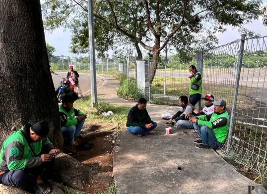 Chandra dan Riki bersama sejumlah driver lainnya saat istirahat sejenak di pinggir jalan Jakarta Garden City (JGC), Jakarta Timur, Sabtu, 2 Mei 2026. (Sumber: Poskota/M Tegar Jihad)
