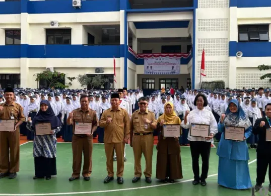 Wali Kota Depok, Supian Suri memberikan penghargaan kepada para guru di Hari Pendidikan Nasional 2026 di SMP N 13, Limo, Kota Depok, Senin, 4 Mei 2026. (Sumber: Poskota/ Angga Pahlevi)