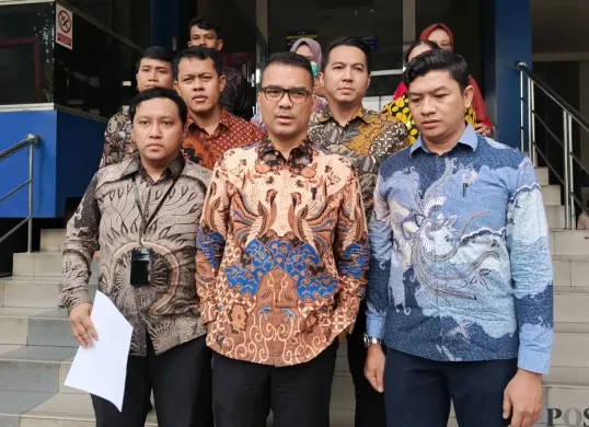 Ketua Umum PSI, Ronald A. Sinaga alias Bro Ron (tengah) melaporkan kasus pemukulan, Selasa, 5 Mei 2026. (Sumber: Poskota/Ali Mansur)