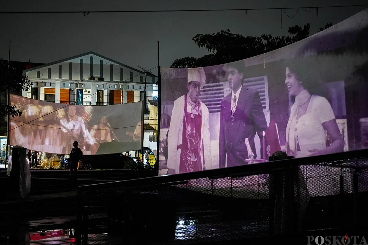 Operator film layar tancap memutarkan rol film era menggunakan mesin proyektor di Waduk Lebak Bulus, Jakarta Selatan, Jum'at, 18 April 2025. (Sumber: Poskota/Bilal Nugraha Ginanjar)