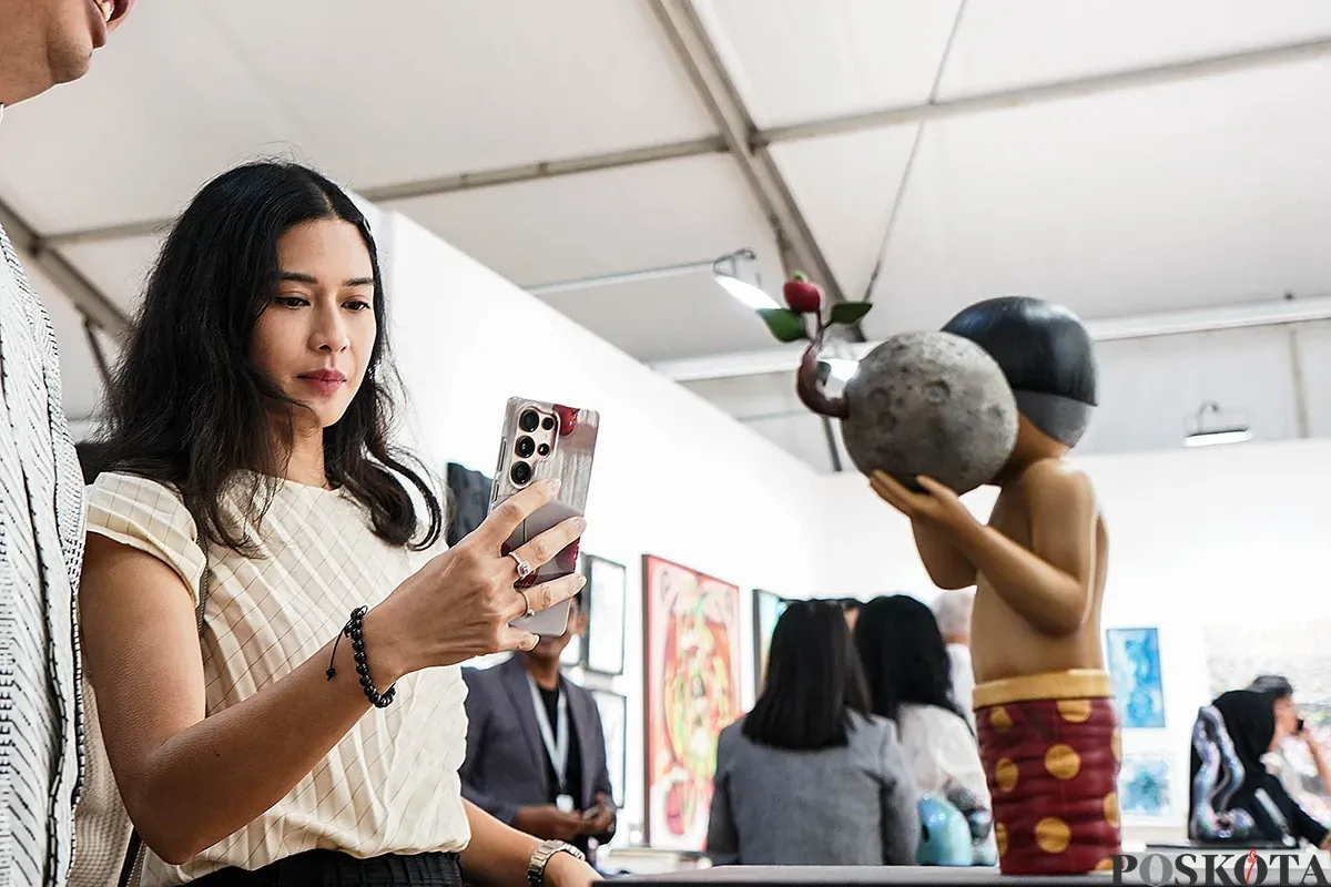 Aktris Dian Sastrowardoyo saat menikmati karya instalasi yang ditampilkan pada pameran Art Jakarta Gardens di Hutan Kota Plataran, Senayan Jakarta, Selasa, 22 April 2025. (Sumber: Poskota/Bilal Nugraha Ginanjar)