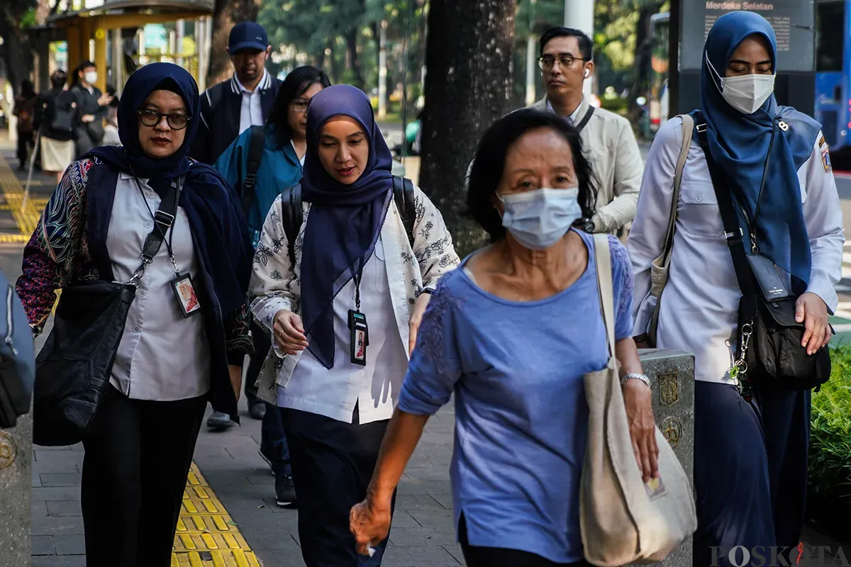 Sejumlah Aparatur Sipil Negara (ASN) Jakarta berjalan menuju halte saat akan menaiki transportasi umum Transjakarta saat berangkat kerja di Halte Balaikota, Jakarta, Rabu, 30 April 2025. (Sumber: Poskota/Bilal Nugraha Ginanjar)