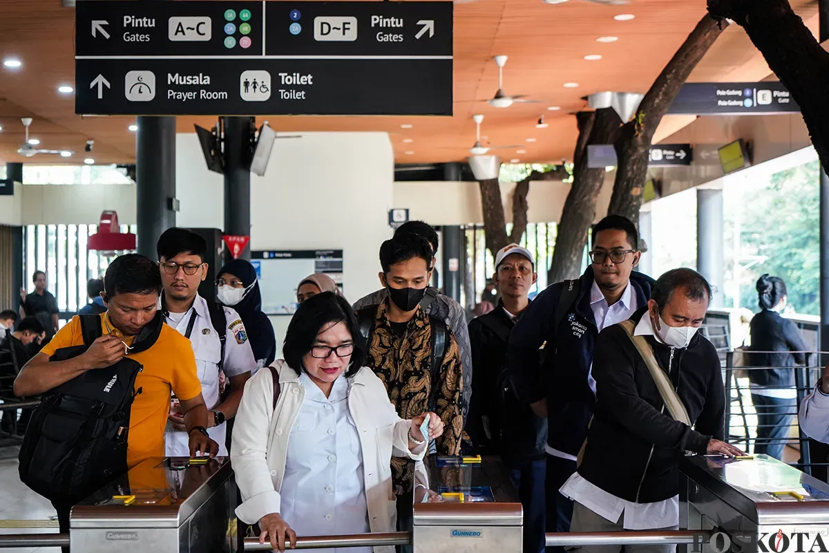 Sejumlah Aparatur Sipil Negara (ASN) Jakarta menempelkan tiket saat akan menaiki transportasi umum Transjakarta saat berangkat kerja di Halte Balaikota, Jakarta, Rabu, 30 April 2025. (Sumber: Poskota/Bilal Nugraha Ginanjar)