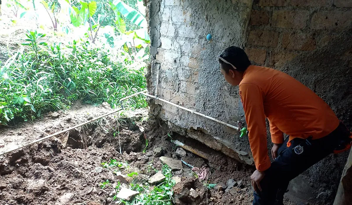 Petugas BPBD Kota Bogor mengecek kondisi rumah yang rusak akibat tanah ambles di Kampung Margabakti, Kelurahan Kertamaya, Kecamatan Bogor Selatan. (Sumber: Dok. BPBD Kota Bogor)