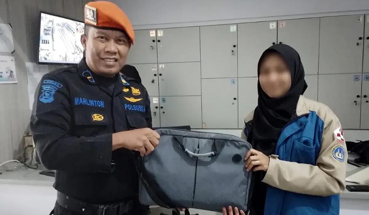 Petugas PT KAI menyerahkan laptop milik penumpang yang tertinggal di dalam kereta. (Sumber: Dok PT KAI Persero)