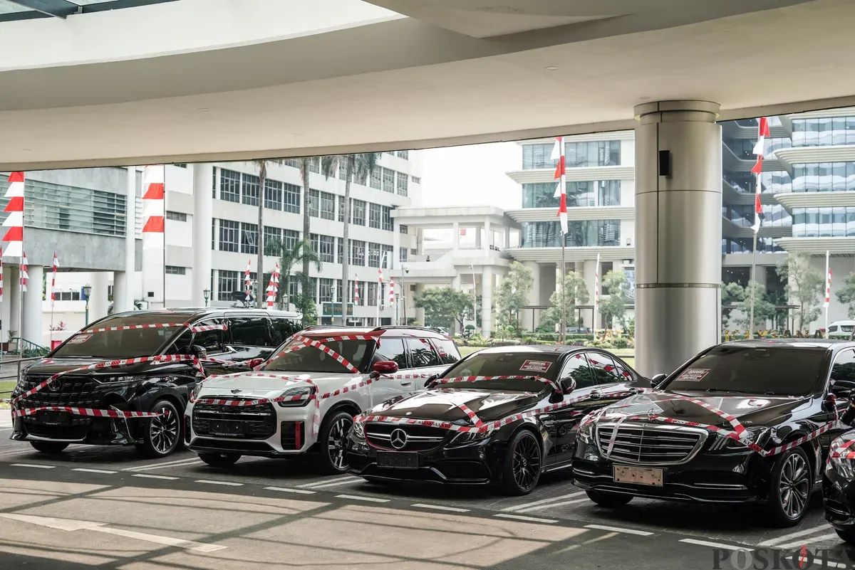 Jurnalis merekam sejumlah mobil sitaan penyidik Jaksa Agung Muda Bidang Tindak Pidana Khusus (Jampidsus) di Kejaksaan Agung, Jakarta, Selasa, 5 Agustus 2025. (Sumber: Poskota/Bilal Nugraha Ginanjar)