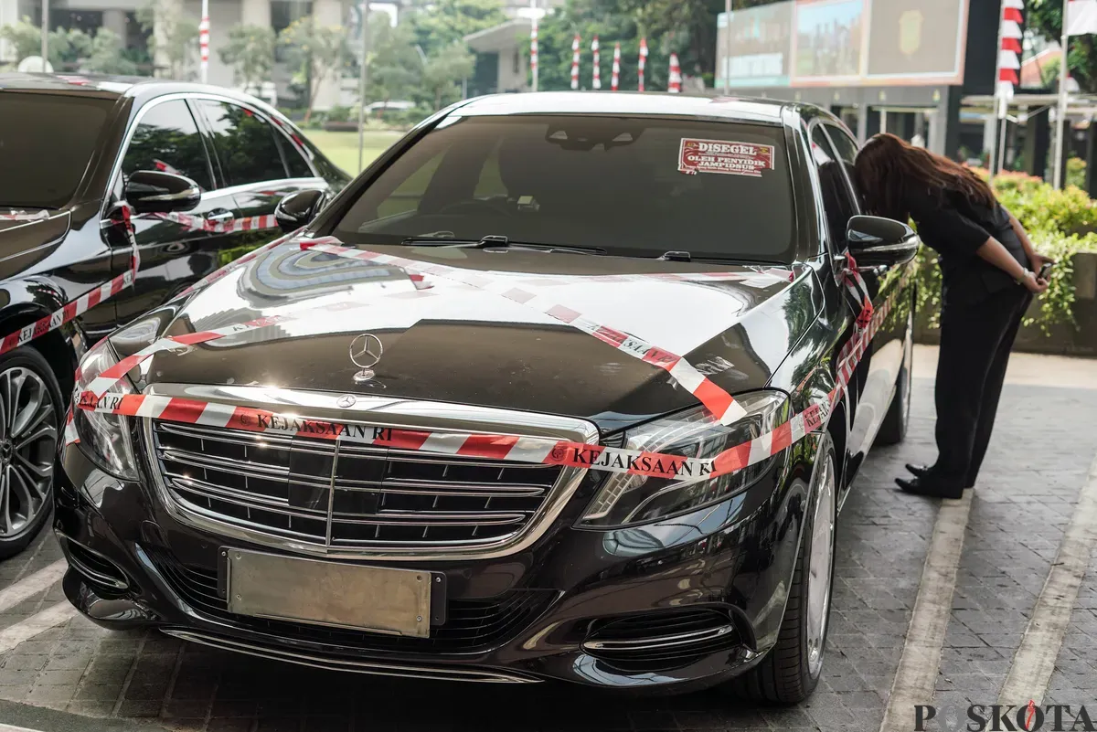 Jurnalis merekam sejumlah mobil sitaan penyidik Jaksa Agung Muda Bidang Tindak Pidana Khusus (Jampidsus) di Kejaksaan Agung, Jakarta, Selasa, 5 Agustus 2025. (Sumber: Poskota/Bilal Nugraha Ginanjar)