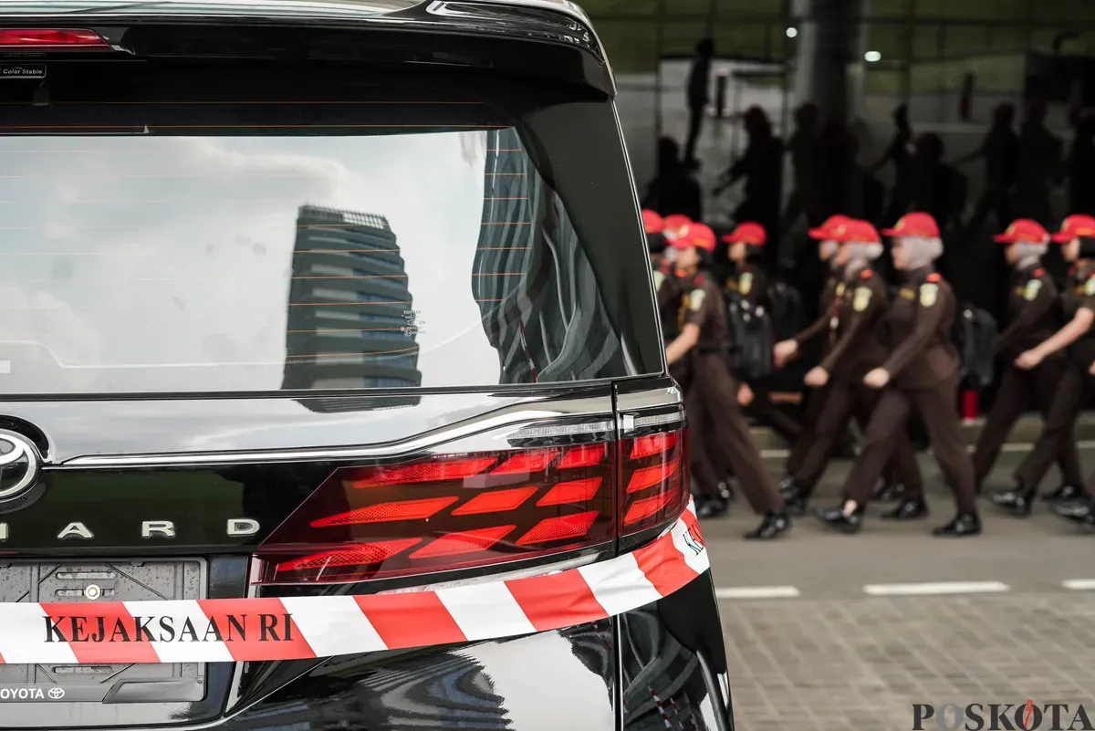 Jurnalis merekam sejumlah mobil sitaan penyidik Jaksa Agung Muda Bidang Tindak Pidana Khusus (Jampidsus) di Kejaksaan Agung, Jakarta, Selasa, 5 Agustus 2025. (Sumber: Poskota/Bilal Nugraha Ginanjar)