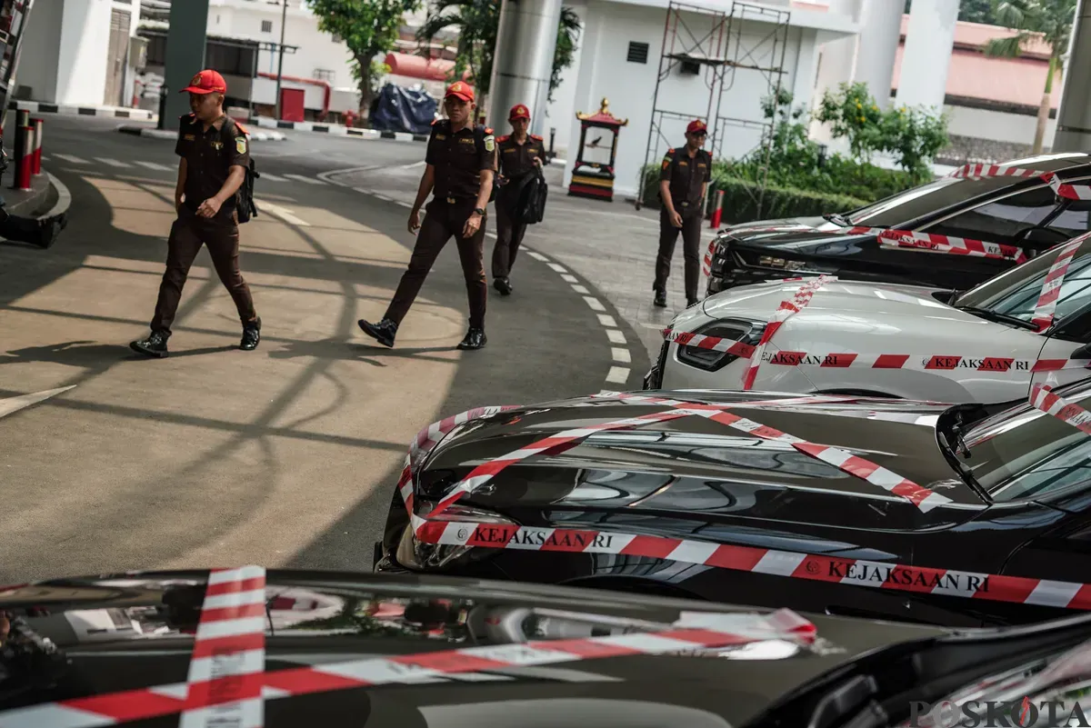 Jurnalis merekam sejumlah mobil sitaan penyidik Jaksa Agung Muda Bidang Tindak Pidana Khusus (Jampidsus) di Kejaksaan Agung, Jakarta, Selasa, 5 Agustus 2025. (Sumber: Poskota/Bilal Nugraha Ginanjar)