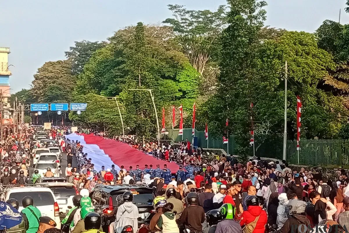 Pemkot Bogor menggelar kirab merah putih dengan membentangkan bendera sepanjang 500 meter, Minggu, 10 Agustus 2025. (Sumber: Poskota/Giffar Rivana)