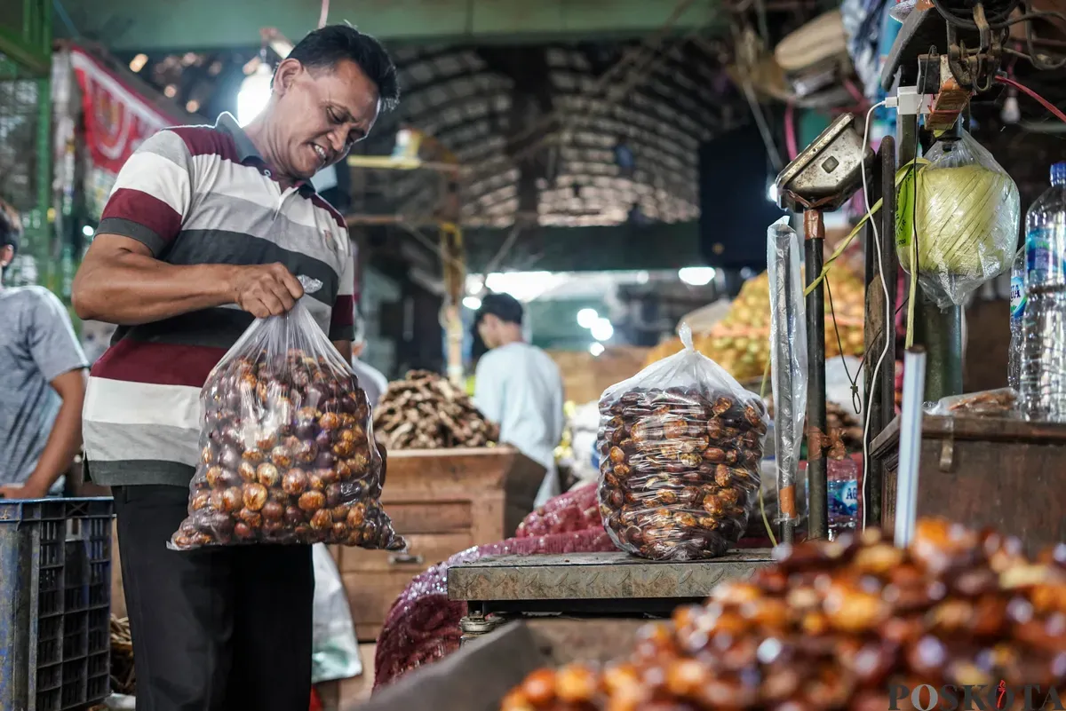 Pedagang jengkol menata buah jengkol di Pasar Induk Kramat Jati dan Pasar Kebayoran Lama, Jakarta, Senin, 11 Agustus 2025. (Sumber: Poskota/Bilal Nugraha Ginanjar)