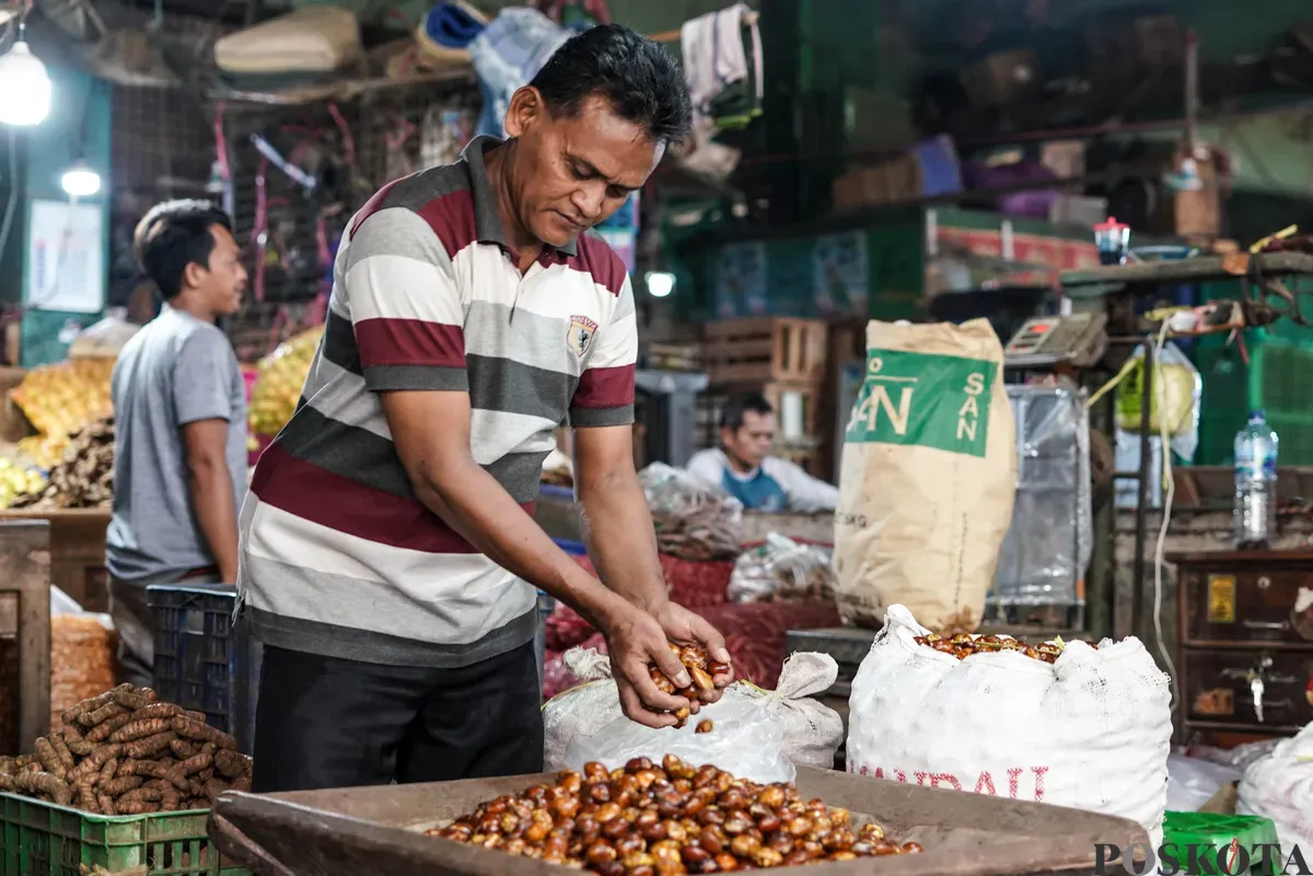 Pedagang jengkol menata buah jengkol di Pasar Induk Kramat Jati dan Pasar Kebayoran Lama, Jakarta, Senin, 11 Agustus 2025. (Sumber: Poskota/Bilal Nugraha Ginanjar)