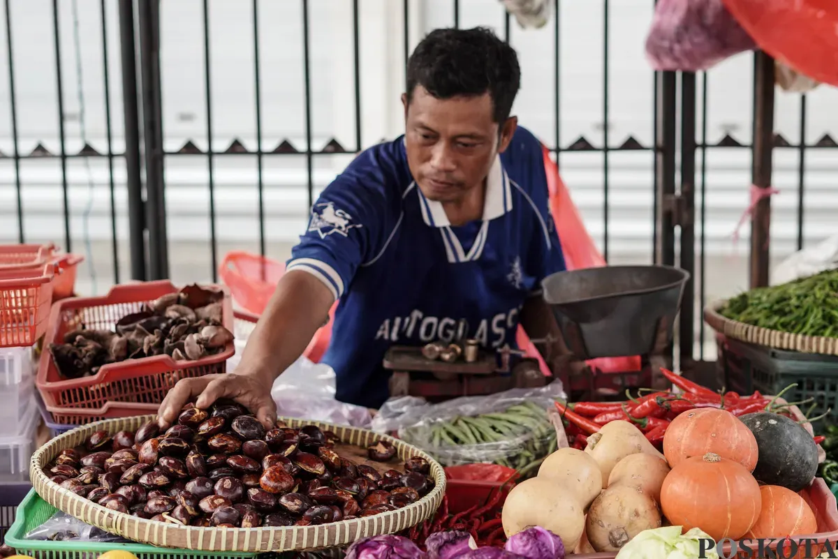 Pedagang jengkol menata buah jengkol di Pasar Induk Kramat Jati dan Pasar Kebayoran Lama, Jakarta, Senin, 11 Agustus 2025. (Sumber: Poskota/Bilal Nugraha Ginanjar)
