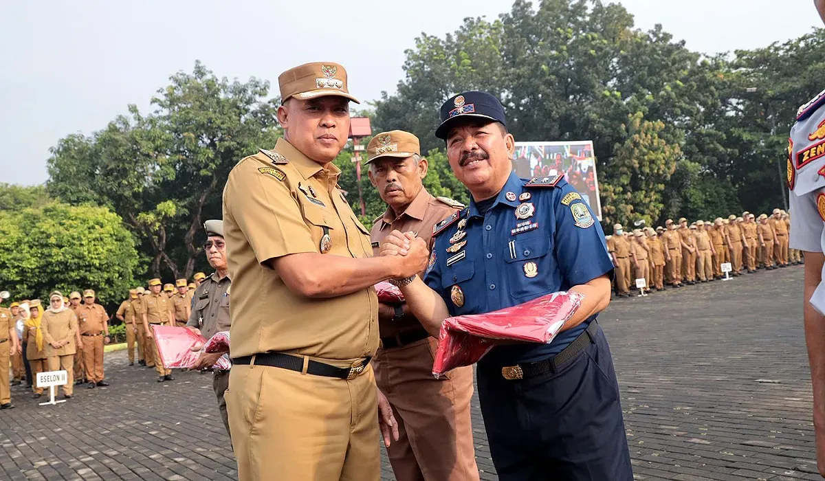 Wali Kota Bekasi, Tri Adhianto, menyerahkan bendera Merah Putih kepada OPD dalam rangka menyambut HUT ke-80 RI di Plaza Pemkot Bekasi, Senin 11 Agustus 2025. (Sumber: Humas Pemkot Bekasi)