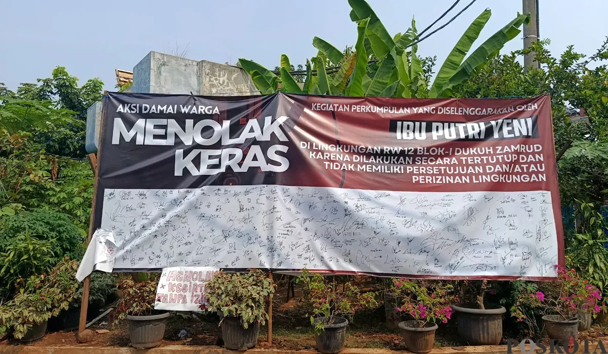 Spanduk petisi penolakan kegiatan keagamaan Umi Cinta yang diduga menyimpang oleh warga Perumahan Dukuh Zamrud, Mustikajaya, Kota Bekasi terbentang lebar di depan rumah Umi Cinta. (Sumber: POSKOTA | Foto: Nurpini Aulia Rapika)