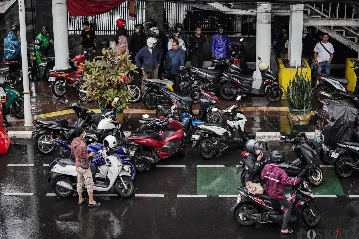 Sejumlah pengendara sepeda motor menerobos hujan di Jalan Salemba, Jakarta, Selasa, 12 Agustus 2025. Badan Meteorologi, Klimatologi, dan Geofisika (BMKG) memprakirakan hujan ringan di seluruh wilayah Jakarta. (Sumber: Poskota/Bilal Nugraha Ginanjar)