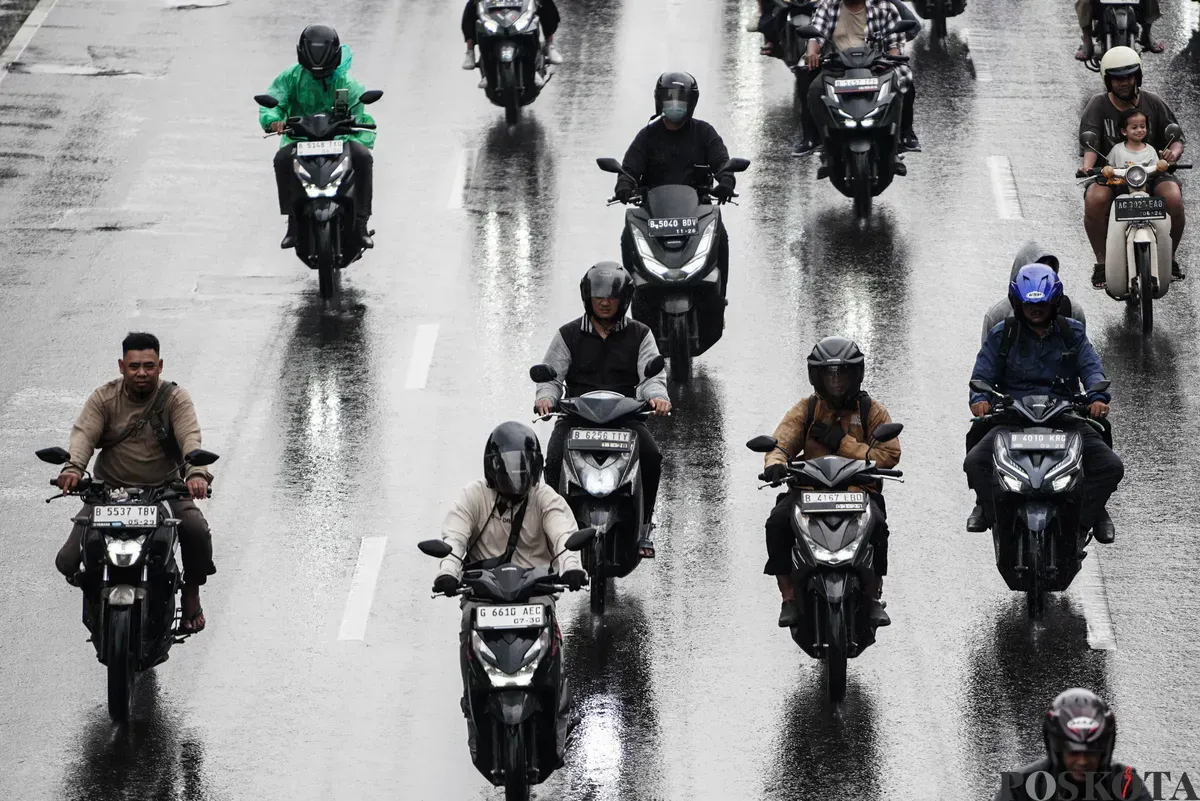 Sejumlah pengendara sepeda motor menerobos hujan di Jalan Salemba, Jakarta, Selasa, 12 Agustus 2025. Badan Meteorologi, Klimatologi, dan Geofisika (BMKG) memprakirakan hujan ringan di seluruh wilayah Jakarta. (Sumber: Poskota/Bilal Nugraha Ginanjar)
