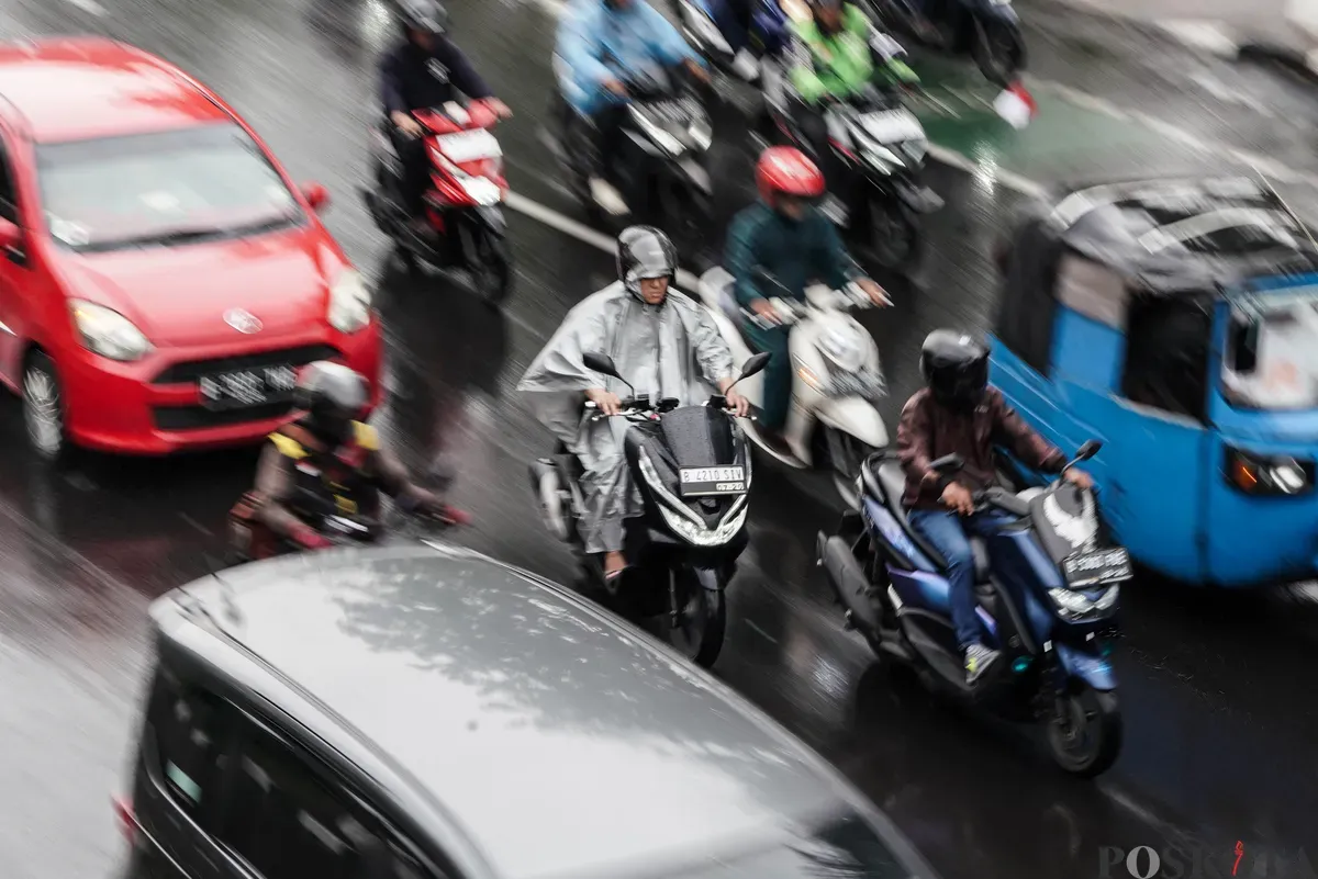 Sejumlah pengendara sepeda motor menerobos hujan di Jalan Salemba, Jakarta, Selasa, 12 Agustus 2025. Badan Meteorologi, Klimatologi, dan Geofisika (BMKG) memprakirakan hujan ringan di seluruh wilayah Jakarta. (Sumber: Poskota/Bilal Nugraha Ginanjar)
