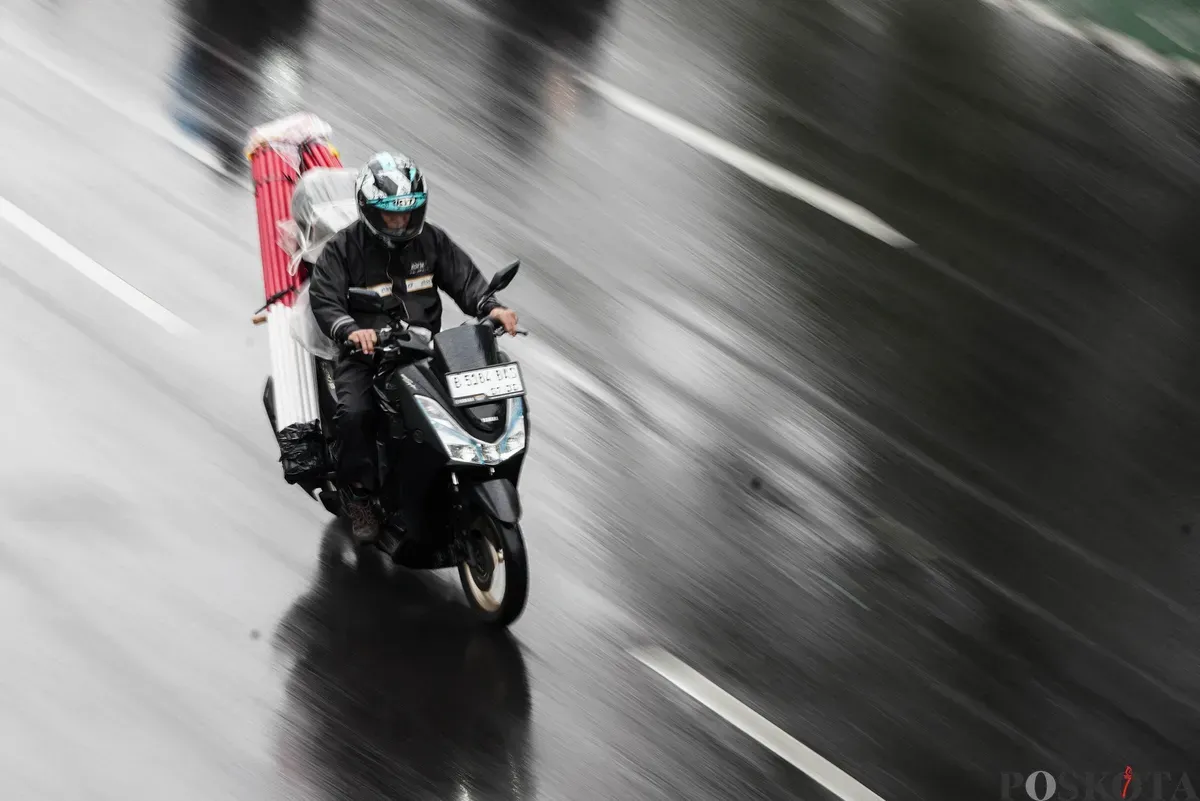 Sejumlah pengendara sepeda motor menerobos hujan di Jalan Salemba, Jakarta, Selasa, 12 Agustus 2025. Badan Meteorologi, Klimatologi, dan Geofisika (BMKG) memprakirakan hujan ringan di seluruh wilayah Jakarta. (Sumber: Poskota/Bilal Nugraha Ginanjar)
