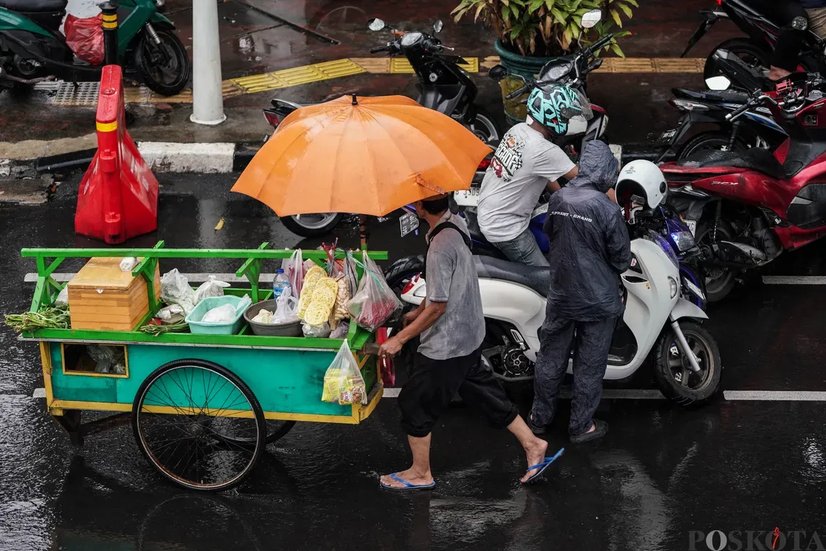 Sejumlah pengendara sepeda motor menerobos hujan di Jalan Salemba, Jakarta, Selasa, 12 Agustus 2025. Badan Meteorologi, Klimatologi, dan Geofisika (BMKG) memprakirakan hujan ringan di seluruh wilayah Jakarta. (Sumber: Poskota/Bilal Nugraha Ginanjar)