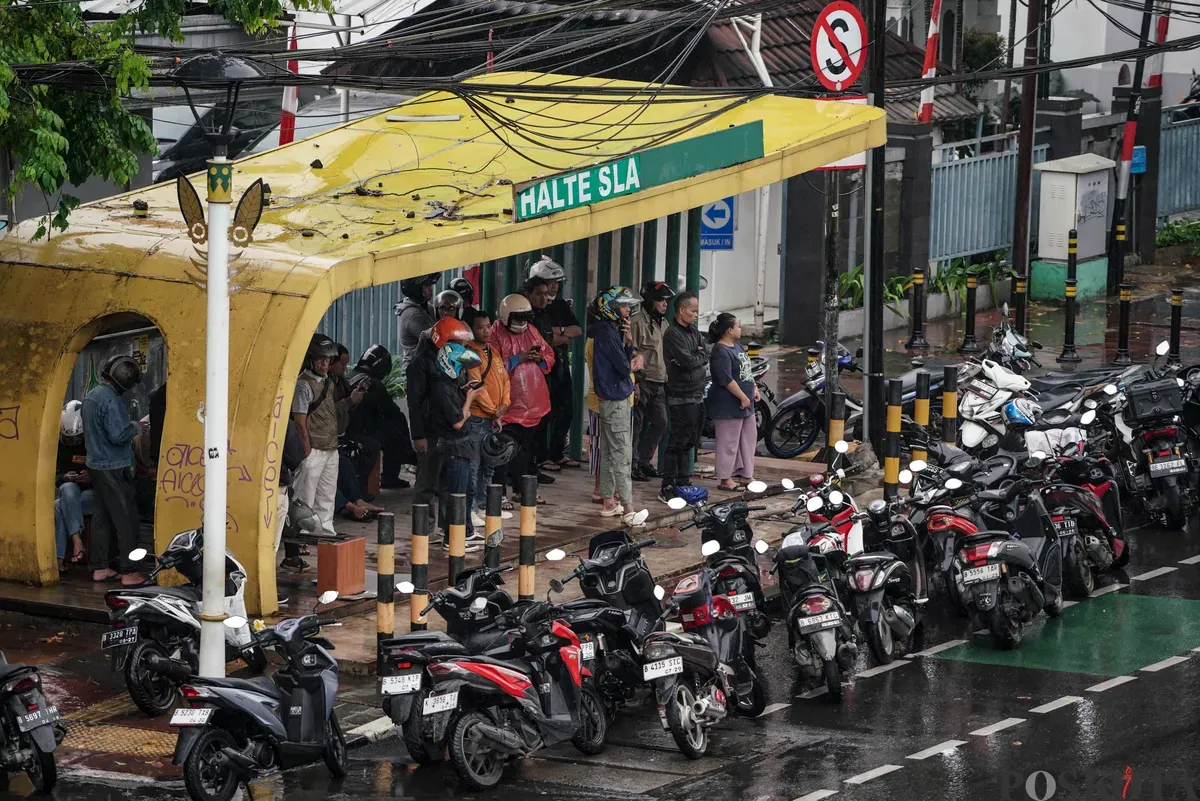 Sejumlah pengendara sepeda motor menerobos hujan di Jalan Salemba, Jakarta, Selasa, 12 Agustus 2025. Badan Meteorologi, Klimatologi, dan Geofisika (BMKG) memprakirakan hujan ringan di seluruh wilayah Jakarta. (Sumber: Poskota/Bilal Nugraha Ginanjar)
