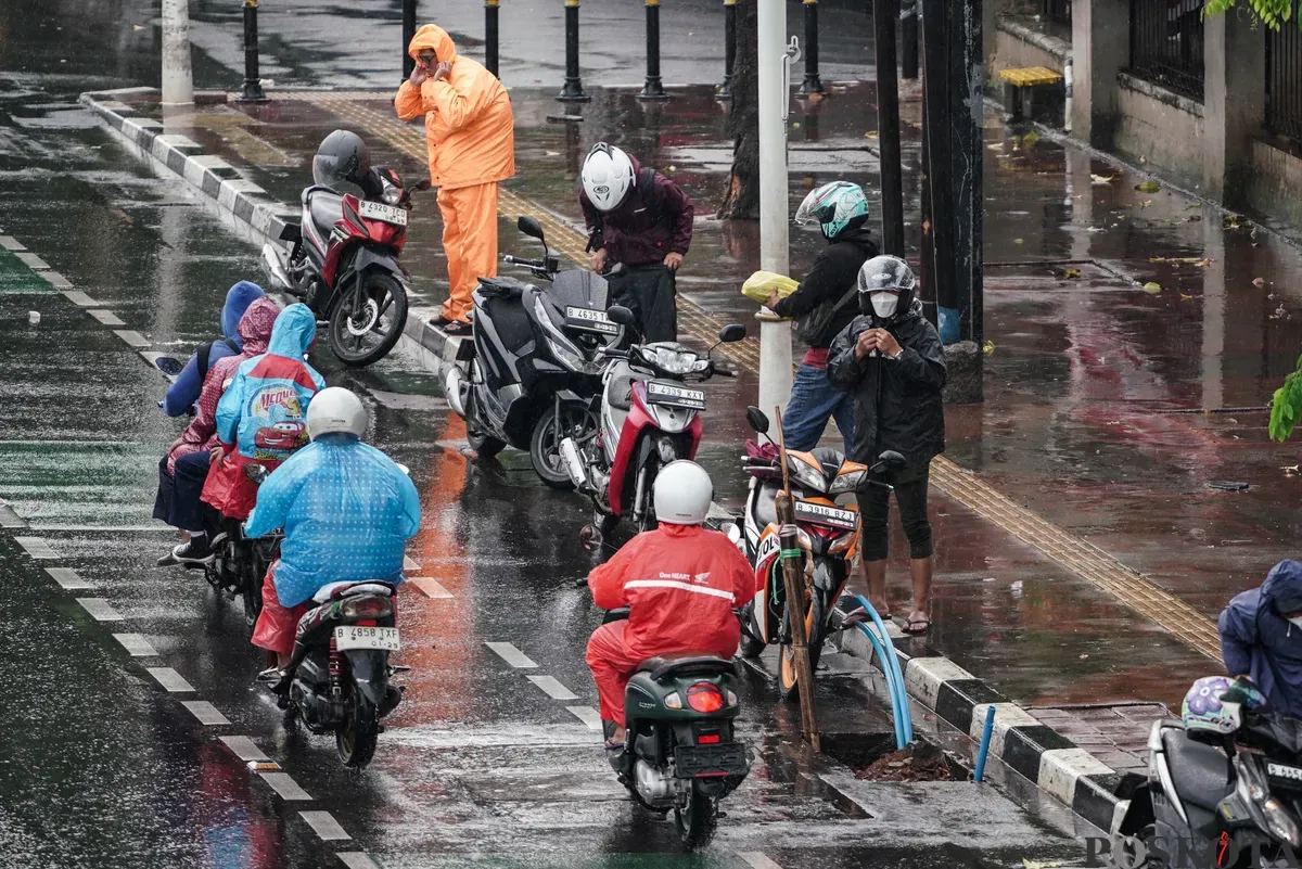 Sejumlah pengendara sepeda motor menerobos hujan di Jalan Salemba, Jakarta, Selasa, 12 Agustus 2025. Badan Meteorologi, Klimatologi, dan Geofisika (BMKG) memprakirakan hujan ringan di seluruh wilayah Jakarta. (Sumber: Poskota/Bilal Nugraha Ginanjar)