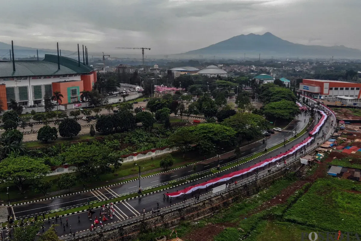 Kirab bendera merah putih sepanjang 600 meter dibawa dari Stadion Pakansari menuju Lapangan Tegar Beriman, Cibinong, Kabupaten Bogor, Kamis, 14 Agustus 2025. (Sumber: Poskota/Giffar Rivana)